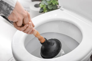 Homeowner plunging a clogged toilet