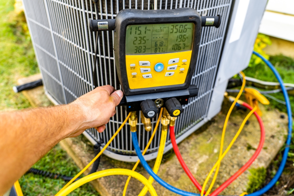 checking the pressure on an outdoor HVAC unit using a digital pressure gauge